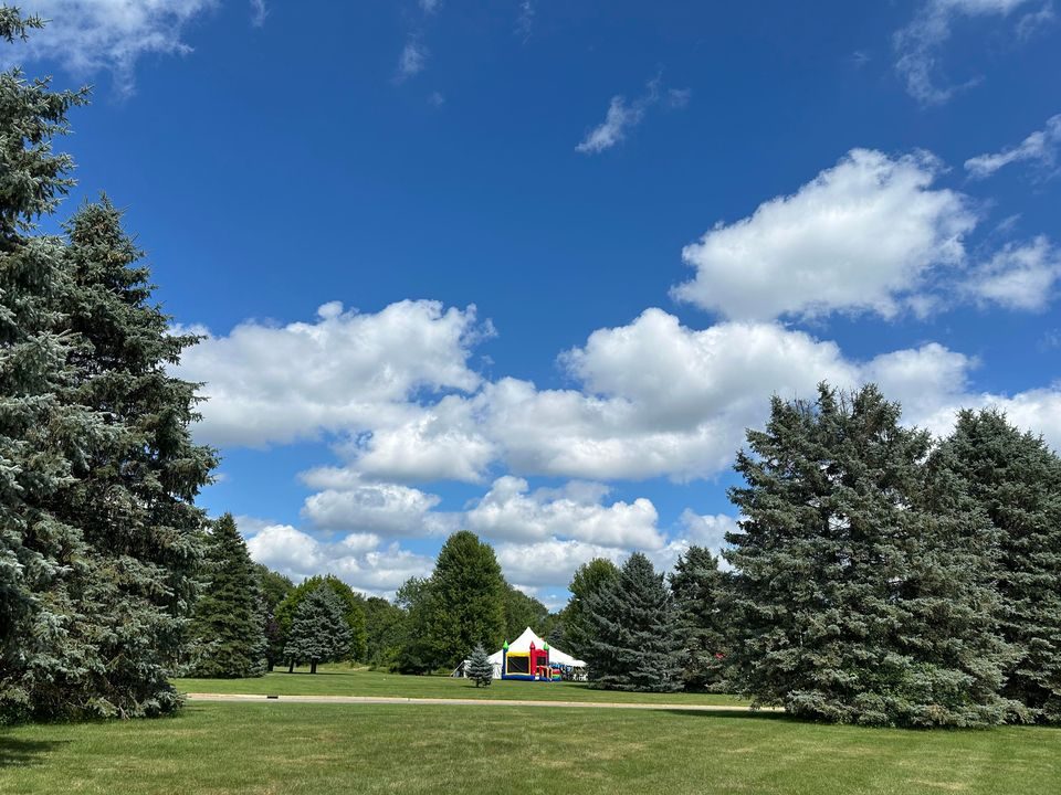 A white peaked tent and an inflatable set up on a Michigan lawn